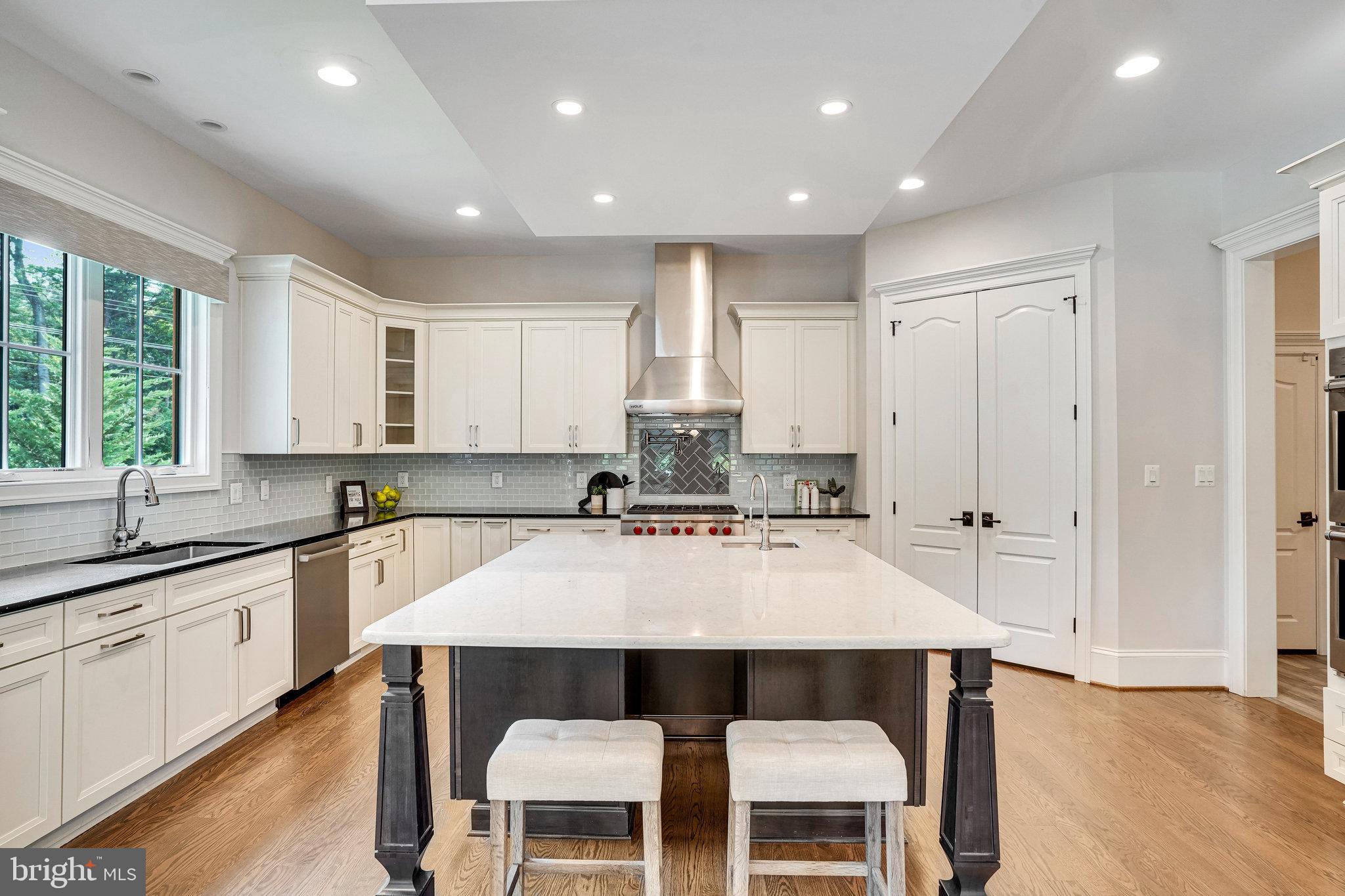 920 Ninovan Road Southeast Vienna, VA 22180 - Photo 14 of 44 a large kitchen with kitchen island a dining table and chairs