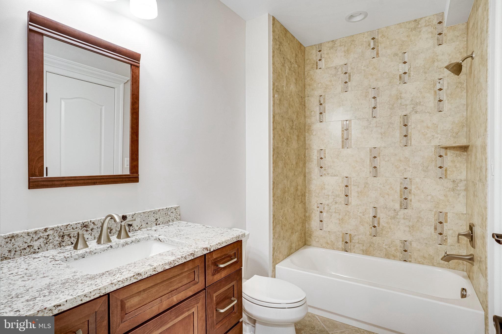 920 Ninovan Road Southeast Vienna, VA 22180 - Photo 40 of 44 a bathroom with a granite countertop sink toilet and shower