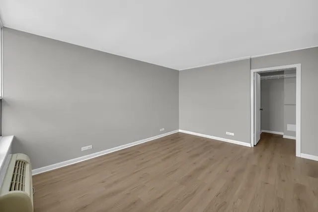a view of an empty room with wooden floor