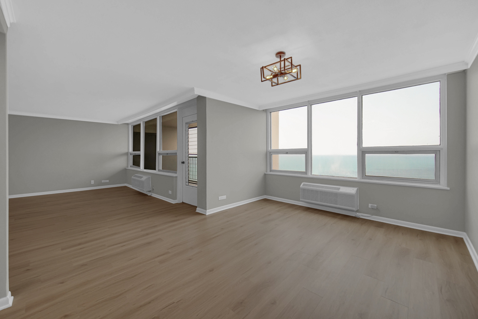 5733 North Sheridan Road, Unit 27C Chicago, IL 60660 - Photo 10 of 23 wooden floor in an empty room with a window