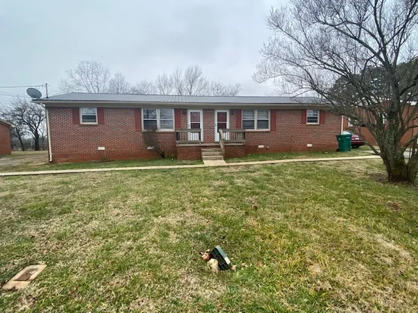 a view of a yard in front of a house with large tree