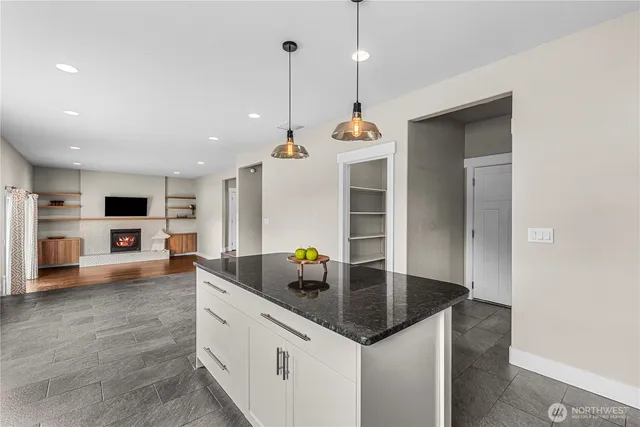 a bathroom with a granite countertop double vanity sink a mirror and a bathtub