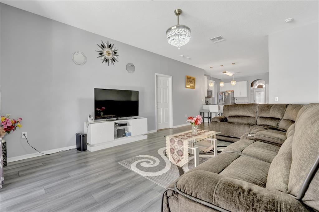 12847 Solola Way Trinity, FL 34655 - Photo 16 of 39 a living room with furniture and a flat screen tv
