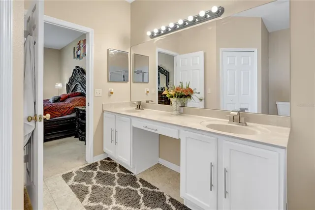 a en suite bathroom with a double vanity sink and a mirror