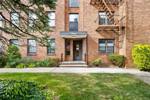front view of a brick house with a yard