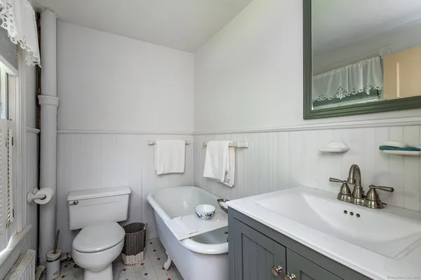 a bathroom with a toilet a sink and mirror