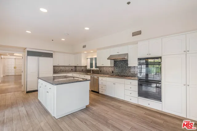 a large kitchen with stainless steel appliances granite countertop a stove and a refrigerator