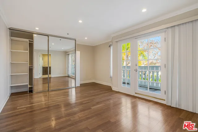an empty room with wooden floor and sliding door