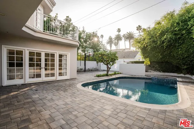 a view of a house with pool fire pit and couches with wooden floor