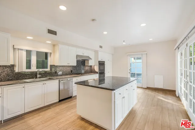 a kitchen with granite countertop white cabinets and white appliances