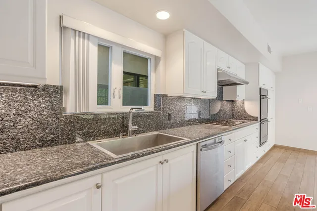 a kitchen with a sink cabinets and window