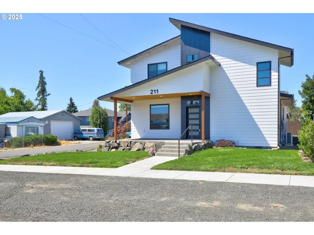 a house with a yard plants and big trees