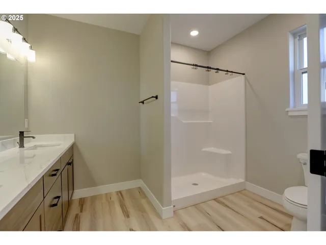 a bathroom with a granite countertop sink a toilet and shower