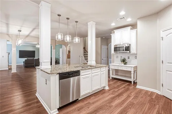 a dining room with wooden floor a chandelier a wooden table and chairs