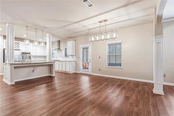 a view of an empty room with window and wooden floor
