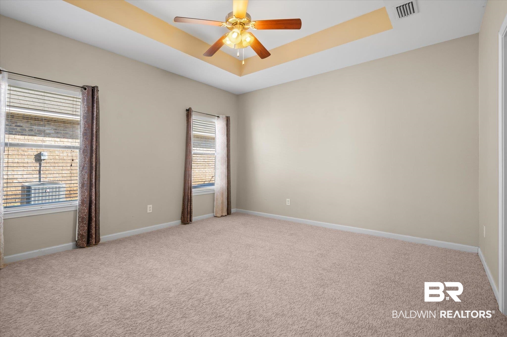 10251 Fionn Loop Daphne, AL 36526 - Photo 9 of 28 Carpeted empty room with ceiling fan and a raised ceiling