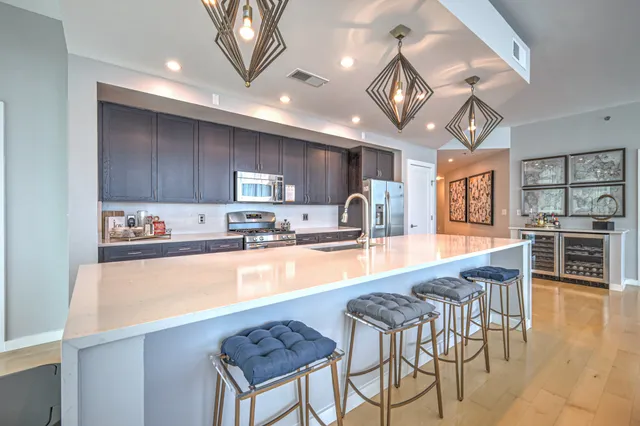 a large kitchen with lots of counter space a sink appliances and a large window