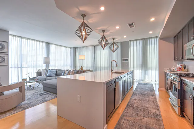 a large kitchen with stainless steel appliances lots of counter space and a sink