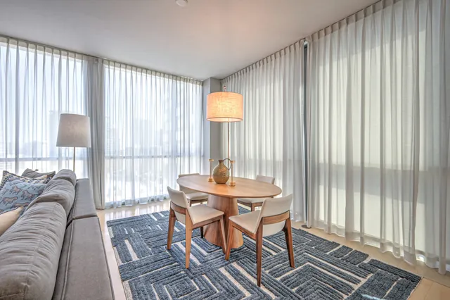 a kitchen with stainless steel appliances granite countertop a sink a stove a refrigerator cabinets and chairs