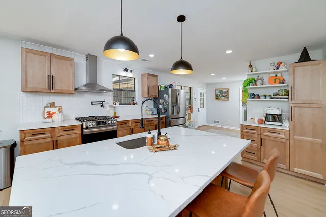 a kitchen with stainless steel appliances kitchen island granite countertop a sink dishwasher and a stove with wooden floor