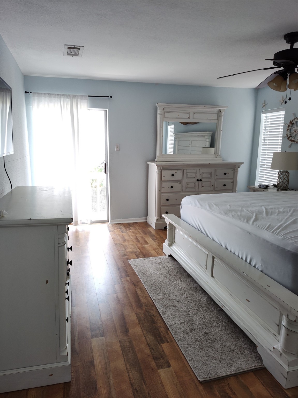500 Tiki Drive, Unit 213 Tiki Island, TX 77554 - Photo 12 of 25 a spacious bedroom with a bed and a flat tv screen on dresser