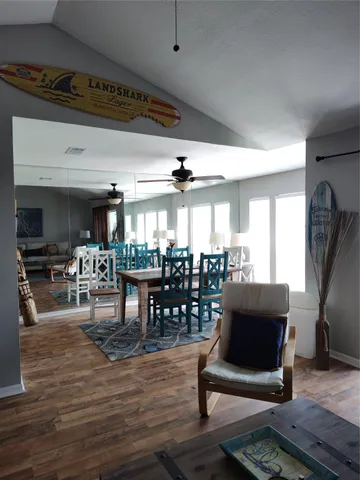 a living room with furniture large window and wooden floor