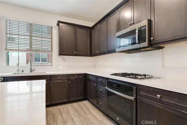 a kitchen with stainless steel appliances granite countertop a sink and a stove