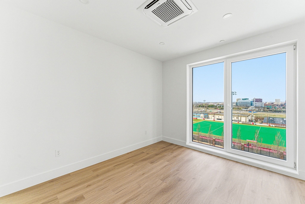 1035 Commonwealth Avenue, Unit 610 Boston, MA 02215 - Photo 11 of 18 an empty room with wooden floor and windows