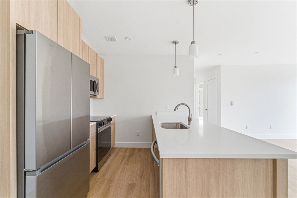 1035 Commonwealth Avenue, Unit 610 Boston, MA 02215 - Photo 2 of 18 a kitchen with stainless steel appliances a refrigerator and a sink