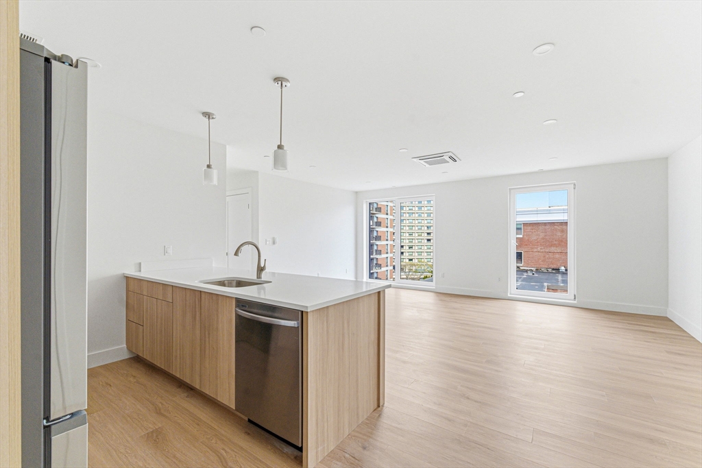 1035 Commonwealth Avenue, Unit 610 Boston, MA 02215 - Photo 3 of 18 a kitchen with stainless steel appliances granite countertop a sink a stove and a wooden floors