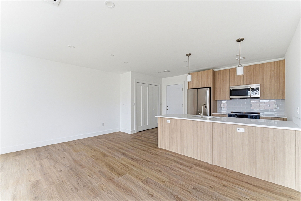 1035 Commonwealth Avenue, Unit 610 Boston, MA 02215 - Photo 5 of 18 a kitchen with stainless steel appliances a refrigerator a stove a sink and white cabinets
