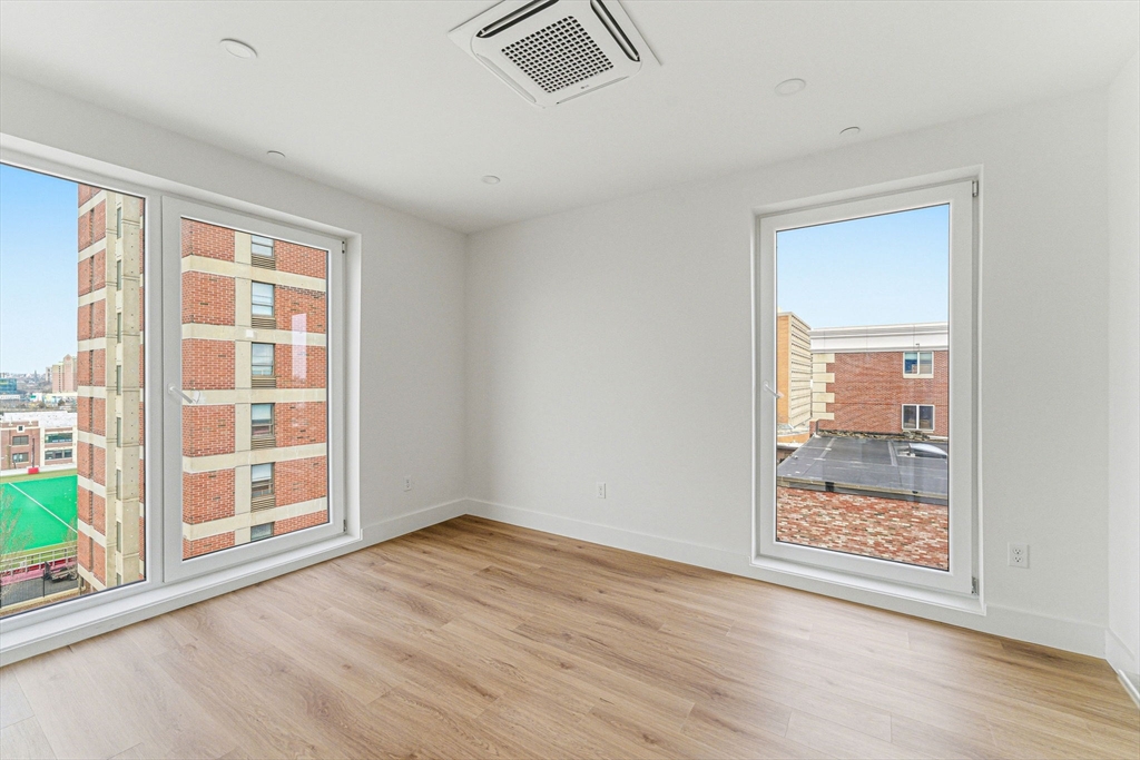 1035 Commonwealth Avenue, Unit 610 Boston, MA 02215 - Photo 9 of 18 an empty room with wooden floor and windows