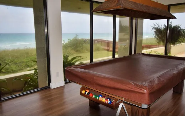 a room with pool table and a floor to ceiling window