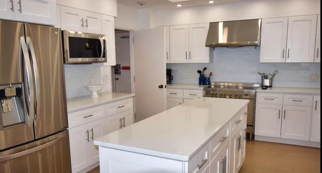 a kitchen with white cabinets and stainless steel appliances