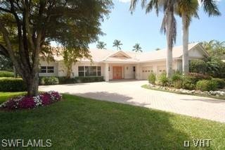 330 Springline Drive Naples, FL 34102 - Photo 1 of 8 a front view of house with yard and green space