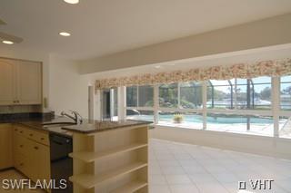 330 Springline Drive Naples, FL 34102 - Photo 4 of 8 a large white kitchen with granite countertop a sink and a large window