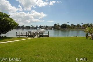 330 Springline Drive Naples, FL 34102 - Photo 7 of 8 a view of a house with a yard next to a lake