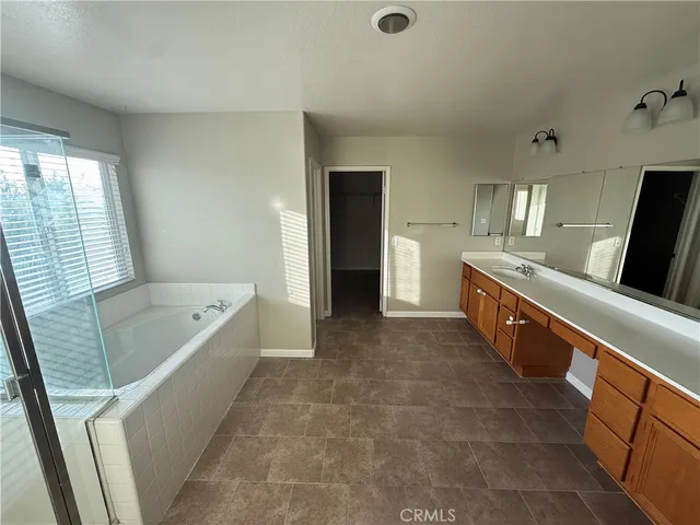 a large bathroom with a tub a double vanity sink and mirror