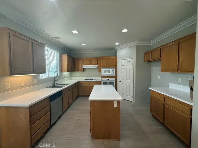 a large kitchen with stainless steel appliances kitchen island granite countertop a sink and cabinets
