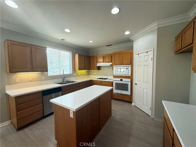 a kitchen with a sink a stove a refrigerator a center island and a window