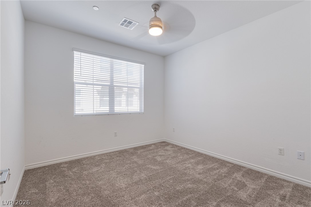 2555 Hampton Road, Unit 8206 Henderson, NV 89052 - Photo 13 of 25 A well-lit bedroom with fresh carpet and a modern ceiling fan for ultimate comfort.