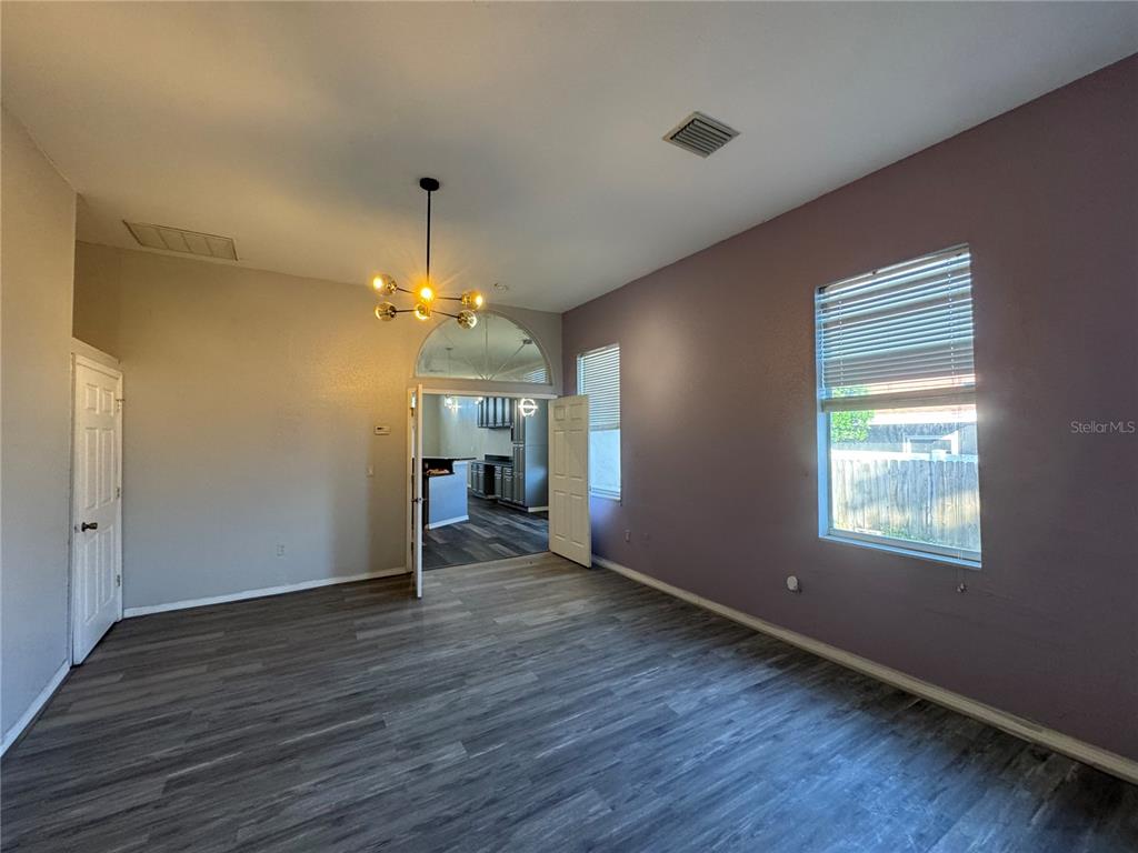 12349 Wasatch Court New Port Richey, FL 34654 - Photo 16 of 34 an empty room with wooden floor a chandelier fan and windows
