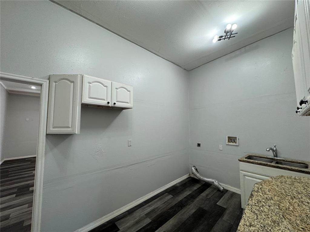 12349 Wasatch Court New Port Richey, FL 34654 - Photo 30 of 34 a room with water heater and wooden cabinets