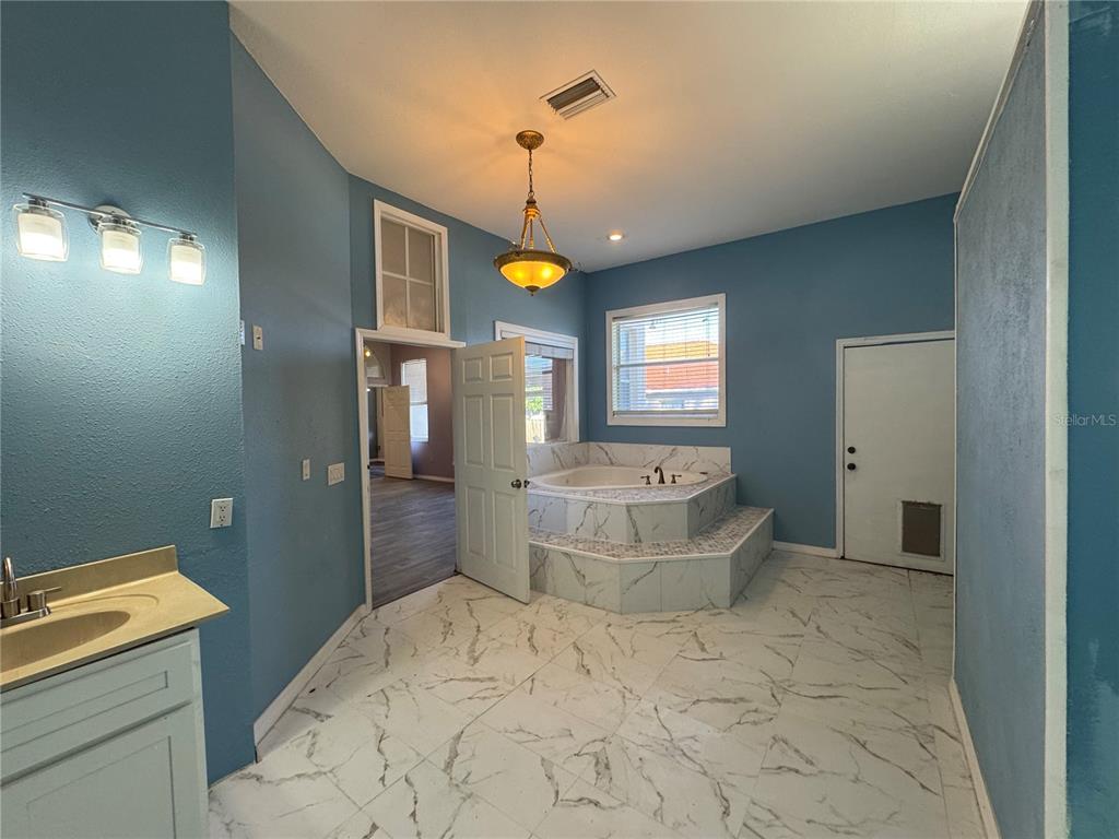 12349 Wasatch Court New Port Richey, FL 34654 - Photo 34 of 34 a spacious bathroom with a granite countertop sink a toilet and mirror
