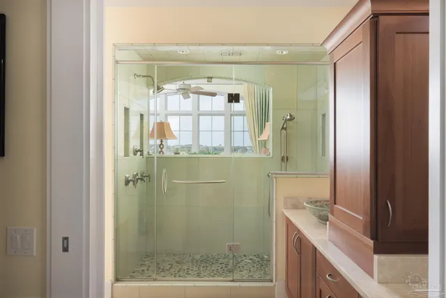 a bathroom with a granite countertop shower a mirror and a sink