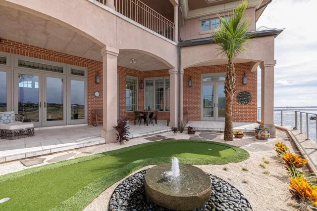 a view of a swimming pool with a lounge chair and palm tree