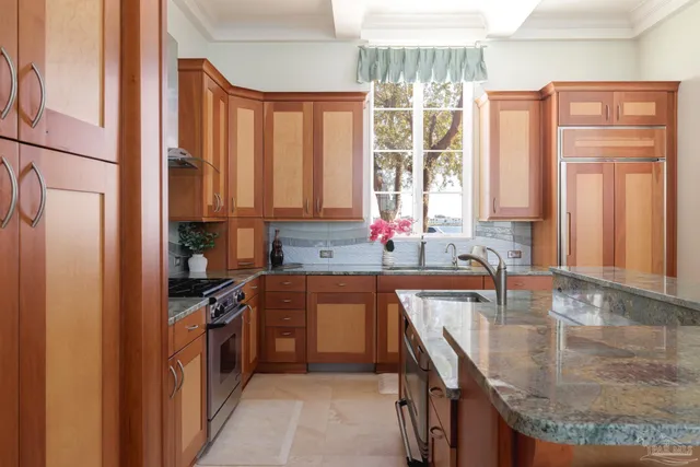 a kitchen with stainless steel appliances granite countertop a stove a sink and a microwave