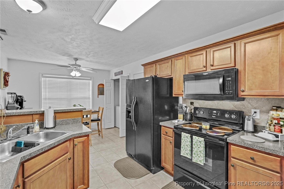 6657 Hillbrook Road Hope Mills, NC 28348 - Photo 12 of 50 a kitchen with stainless steel appliances granite countertop a refrigerator stove and sink
