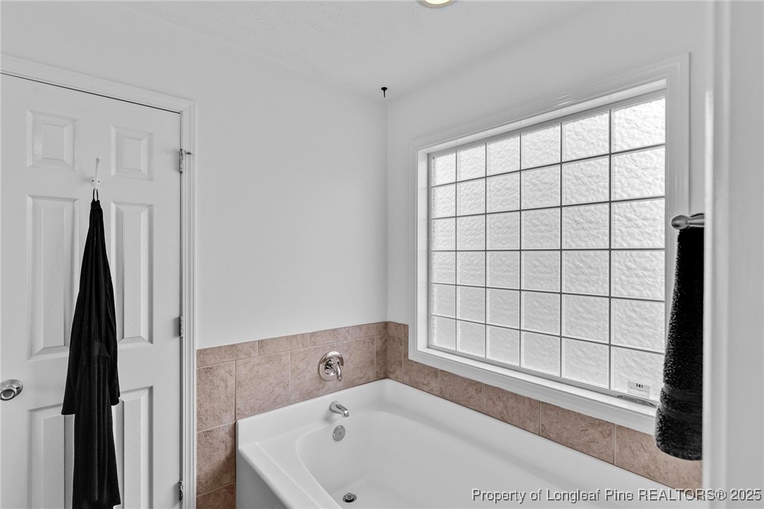 6657 Hillbrook Road Hope Mills, NC 28348 - Photo 21 of 50 a bathroom with a bathtub and next to a window