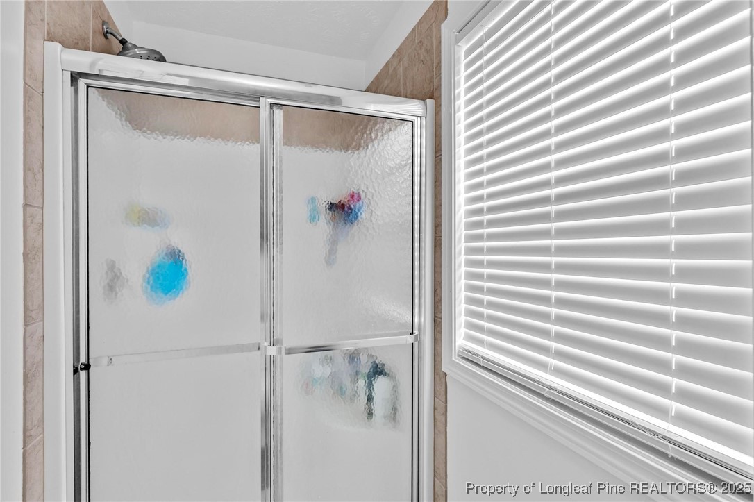 6657 Hillbrook Road Hope Mills, NC 28348 - Photo 22 of 50 a bathroom with a shower and a window
